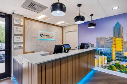 a reception desk in a office with a city skyline at Clarion Pointe Morrow - Atlanta South in Morrow
