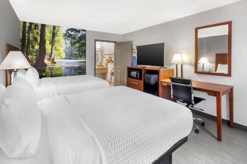a hotel room with two beds and a desk and a computer at Clarion Pointe Morrow - Atlanta South in Morrow