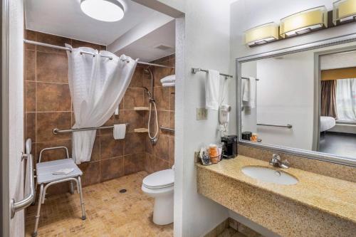 a bathroom with a sink and a toilet and a mirror at Clarion Pointe Morrow - Atlanta South in Morrow