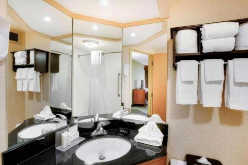 a bathroom with two sinks and a large mirror at Pittsburgh Airport Inn and Suites in Coraopolis