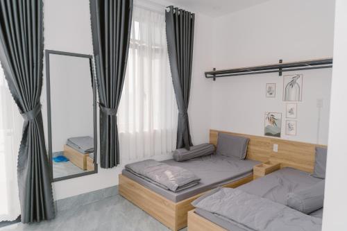 a room with two beds and a mirror at SmartCity Hometel in Can Tho