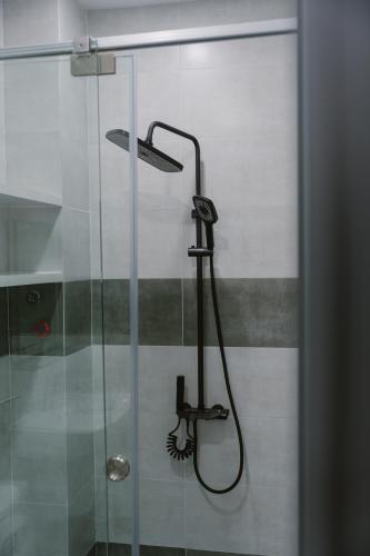 a shower with a shower head and a glass door at SmartCity Hometel in Can Tho