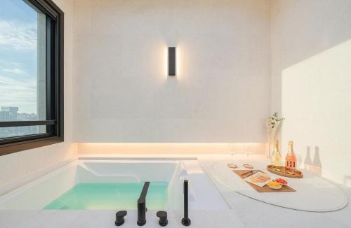 a bathroom with a bath tub with a sink at H-AVENUE Hotel Yeongdeungpo in Seoul