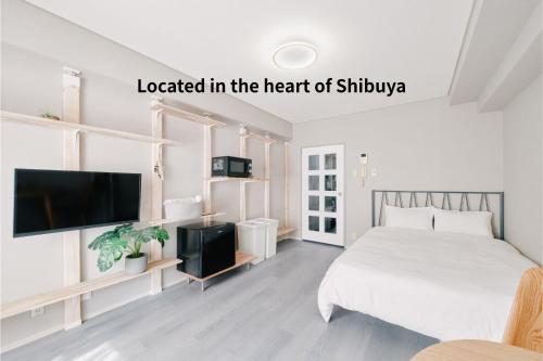 a bedroom with a bed and a flat screen tv at Shibuya Apartment Room Dogenzaka in Tokyo