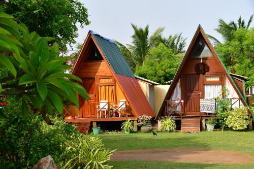 a wooden house with a gambrel roof at Thats why beach hotel in Trincomalee