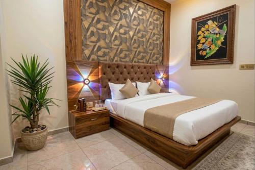 a bedroom with a large bed and a potted plant at hotel hill top inn vatva in Ahmedabad