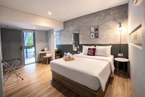 a hotel room with a large bed and a table at Turuku in Bandung