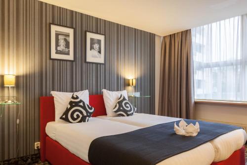 a hotel room with two beds and a window at Amsterdam Hotel Uithoorn in Uithoorn