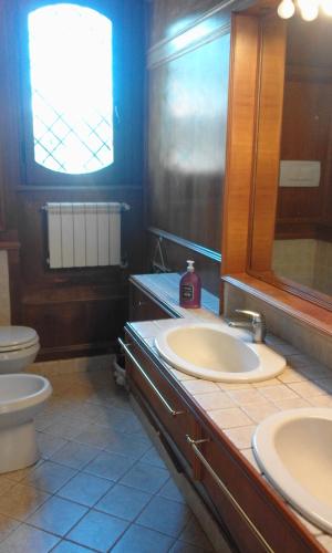 a bathroom with a sink and a toilet and a mirror at La casa di Nataly in Fregene
