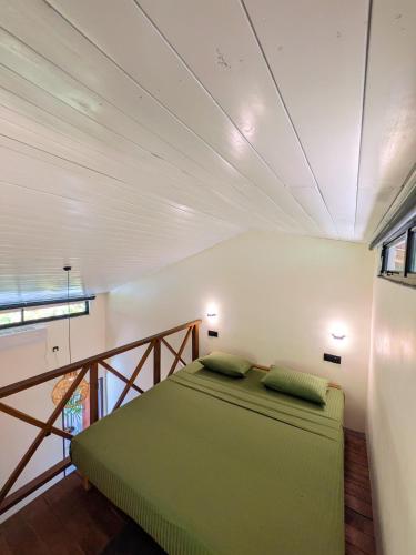 a bedroom with a green bed in a room at Mariposa Hiriketiya in Dickwella