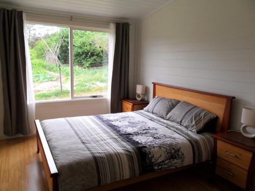 Un dormitorio con una cama grande y una ventana en Elvenhome Farm, en Deloraine