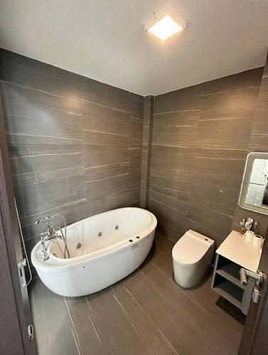 a bathroom with a tub and a toilet and a sink at Osaka Villa Phan Thiet in Ấp Bình Hưng