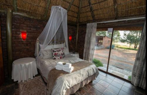 a bedroom with a bed with a canopy at Sundown Lodge and Confrence in Aliwal North