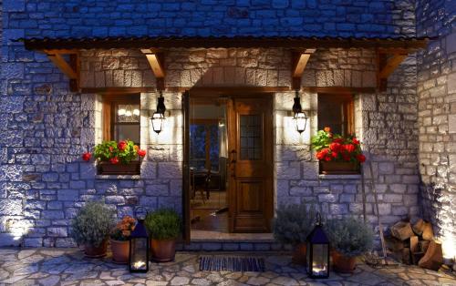 a stone house with potted plants and a door at Levanta in Méga Khoríon