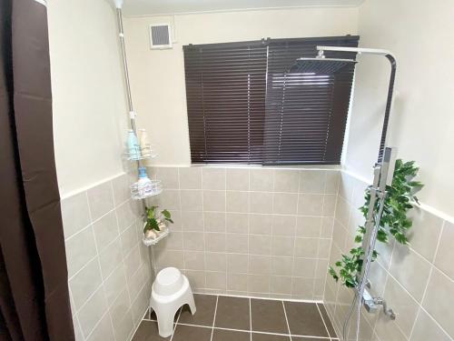 a bathroom with a shower with a toilet in it at 外人住宅ーアメリカンビレッジ車20分 in Urazoe