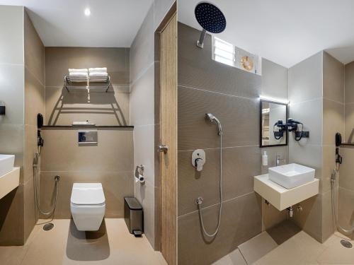 a bathroom with a toilet and a shower and a sink at Monday Premium Madhapur in Hyderabad