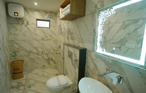 a bathroom with a sink and a toilet and a window at Serenity By The Ganges in Haridwār