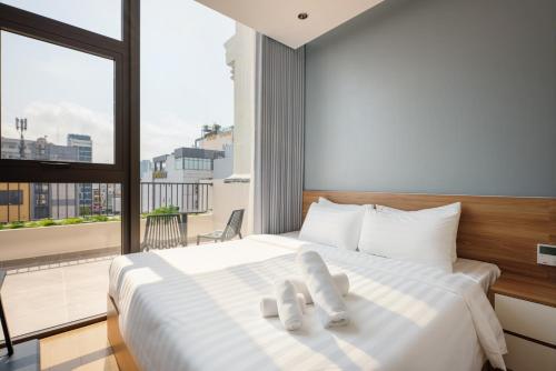 a bedroom with a large bed with white towels on it at Anora Home by BRIO in Danang