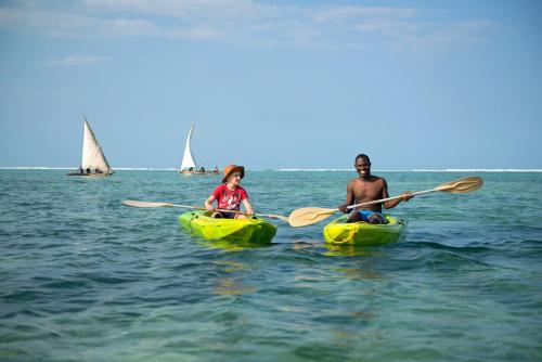 a man and a girl are in kayaks in the water at Matemwe Beach House in Matemwe