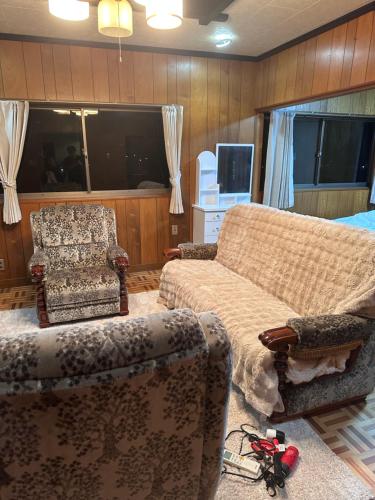 a living room with two chairs and a couch at Lagom Homestay in Yoshino