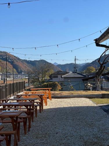 a row of wooden benches with mountains in the background at Lagom Homestay in Yoshino