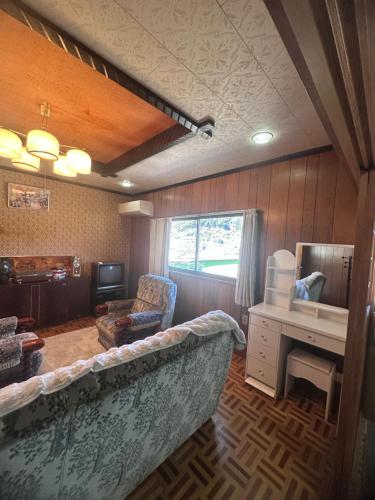 a living room with a couch and a desk at Lagom Homestay in Yoshino