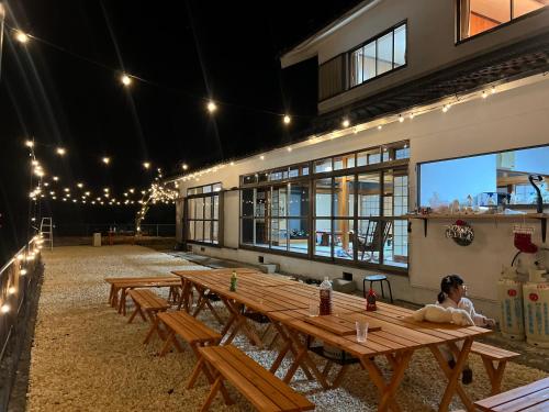 a group of picnic tables in a building with lights at Lagom Homestay in Yoshino
