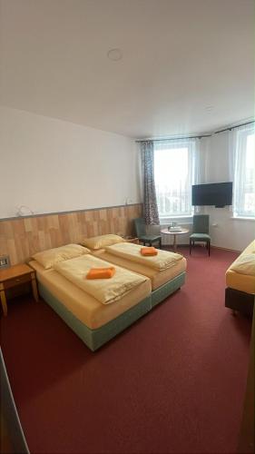 a bedroom with two beds and a room with two chairs at Hotel U Branky in Stříbro