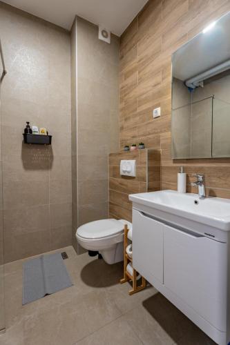 a bathroom with a white sink and a toilet at HM Apartments in Inđija