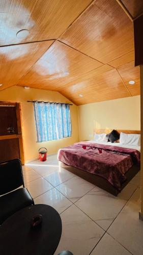 a bedroom with a large bed with a wooden ceiling at Mahi camping & cottages in Jagatsukh