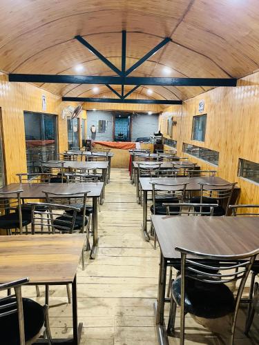 an empty dining room with tables and chairs at Mahi camping & cottages in Jagatsukh