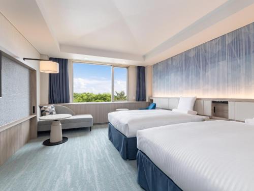 a hotel room with two beds and a window at Kiyosato Kogen Resort in Hokuto