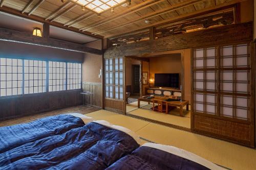 a room with two beds and a television in it at Yunoyado Irifune in Aso