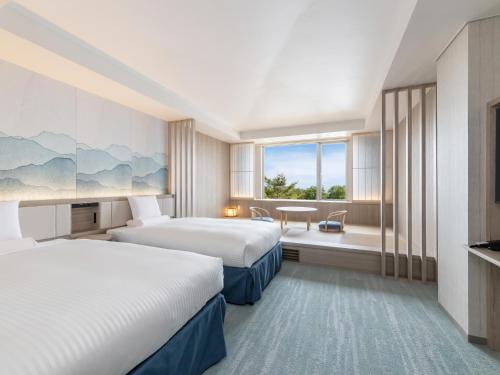 a hotel room with two beds and a desk at Kiyosato Kogen Resort in Hokuto