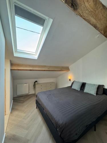 a bedroom with a large bed with a skylight at Logis Fontaines in Champagnat
