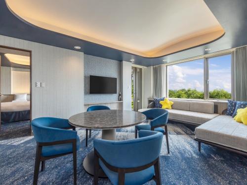 a living room with a couch and a table and chairs at Kiyosato Kogen Hotel in Hokuto