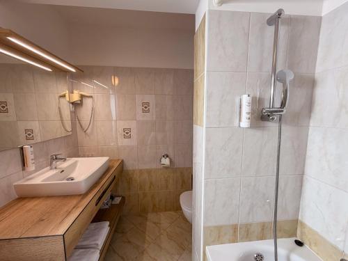 a bathroom with a sink and a shower at Hotel Tripič, restaurant and pizzeria in Bohinj