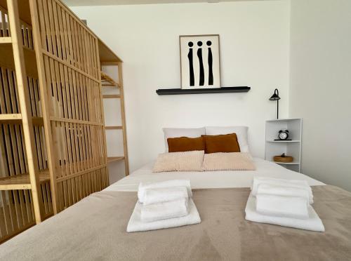 a bedroom with a large bed with two pillows at Studio le Capricorne 22 in Martigny-Ville