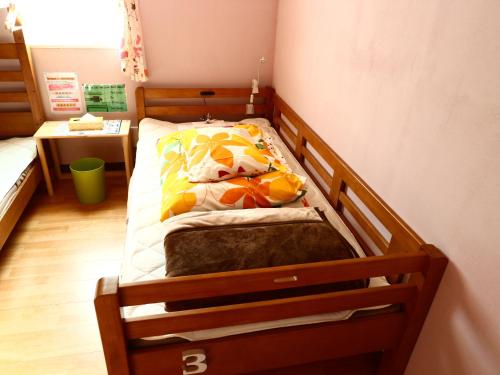 a small bed in a room with a wooden frame at ホステル富士山 結 in Fujiyoshida