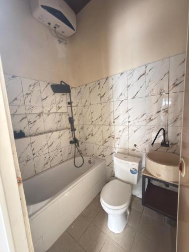 a bathroom with a toilet and a tub and a sink at Villa Bianca Lovina by GEMA MANAGEMENT BALI in Lovina