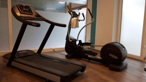 a gym with a treadmill and a phone on it at Parkhotel Kevelaer in Kevelaer