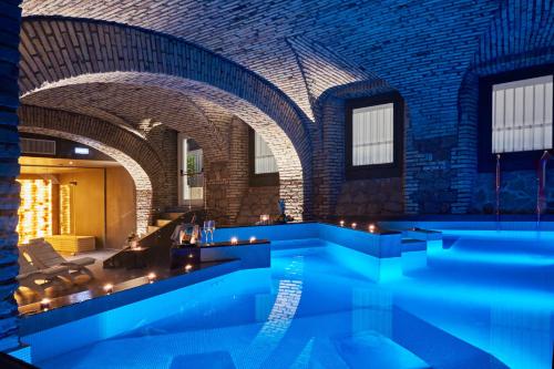 a swimming pool in a building with blue lighting at Hotel The Building in Rome