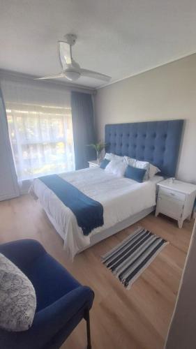 a bedroom with a large bed with a blue headboard at 130 Brookes Hill Suites in Port Elizabeth