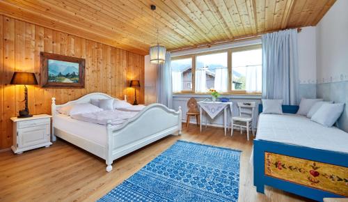 a bedroom with two beds and a dining table at Gästehaus Eder Oberammergau in Oberammergau