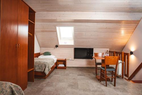 a bedroom with a bed and a desk and a television at Hotel Tripič, restaurant and pizzeria in Bohinj