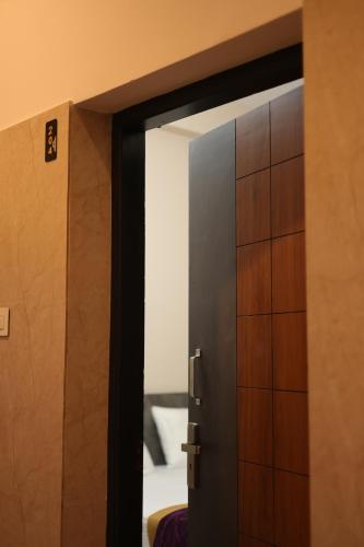 an open door leading to a room with a bed at RUBY Residency in Palni