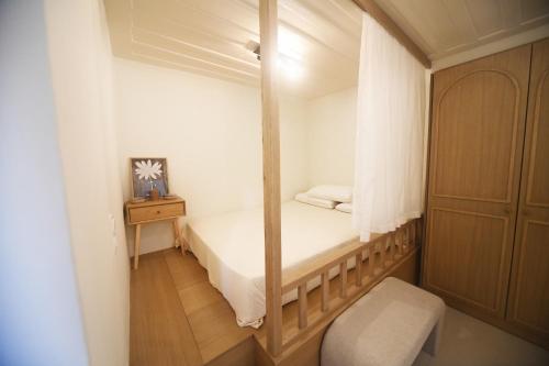 a small bedroom with a bed and a mirror at Anoi Kalymnos in Khoríon