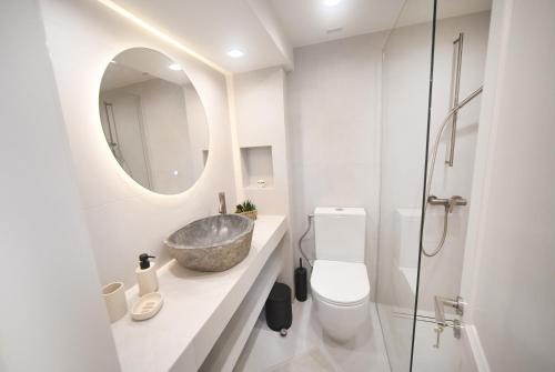 a bathroom with a sink and a toilet and a mirror at Anoi Kalymnos in Khoríon
