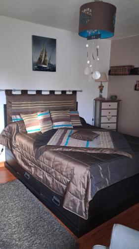 a bedroom with a large bed with a sailboat on it at Aux Volets Bleus in Sibiril