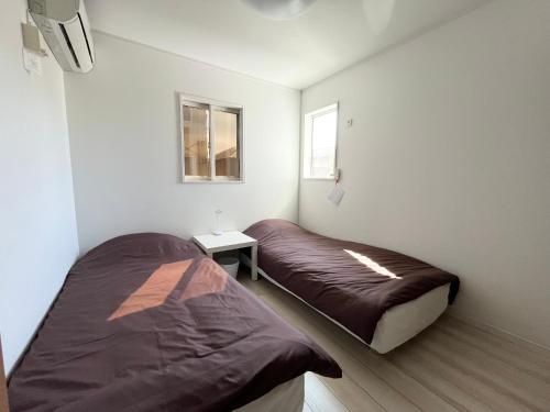 a bedroom with two beds and a window at Ano House 女性専用Women's Guesthouse in Kamakura